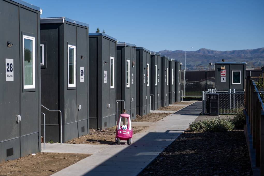 Shipping containers converted to homes line the perimeter of the Evans Lane interim housing facility located on city-owned land, in San José, on Jan. 30, 2023. (Beth LaBerge/KQED)